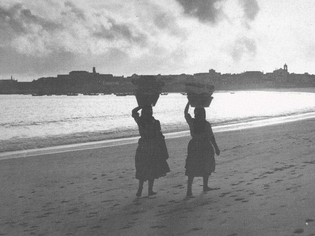 Regresso do rio, com a roupa lavada à cabeça, vendo-se o extenso areal até à então vila de Peniche, década de 1940, fotografia de Luís Correia Peixoto