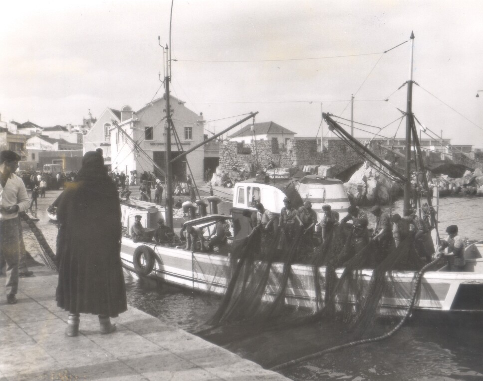 Traineira junto ao cais da Ribeira, com a Estação de Socorros a Náufragos e o Forte das Cabanas em segundo plano, 1970-74